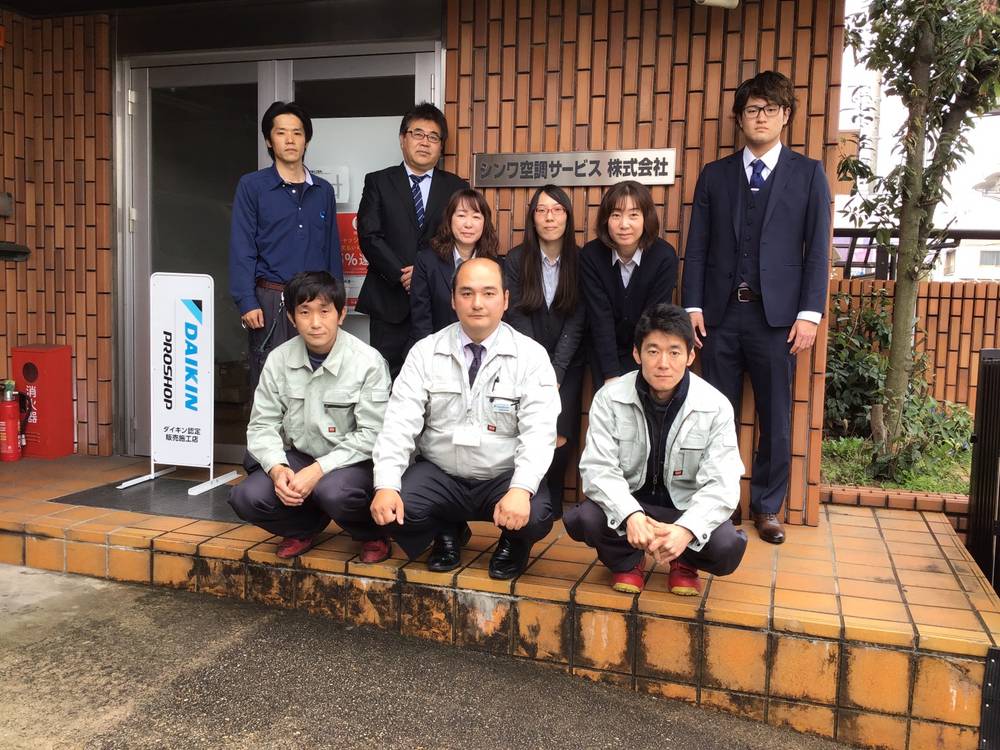 名古屋のエアコン取付・修理を手掛ける企業の新入社員を迎えたスタッフの集合写真。