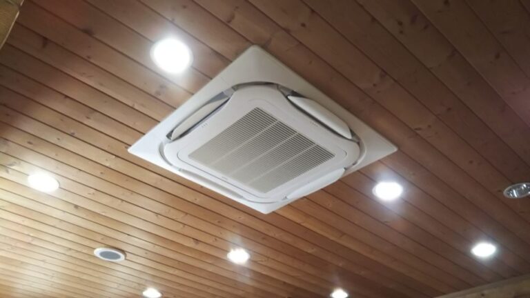 木目天井の中央に設置された埋込式天井用エアコンユニットのアップ写真