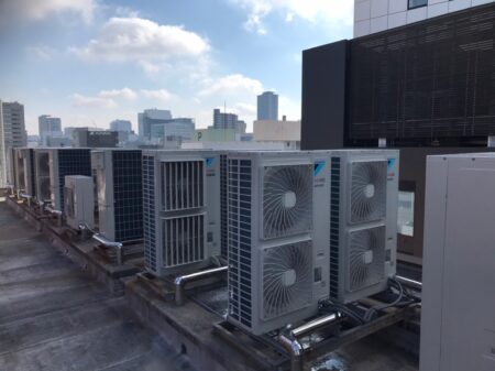 名古屋の高層ビル屋上に並ぶ業務用エアコンの取付・更新工事の現場写真
