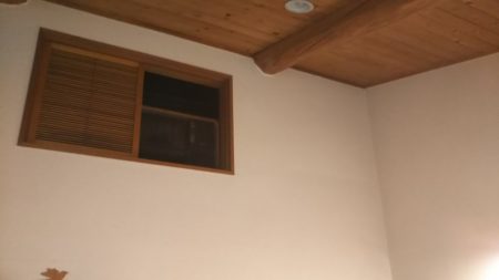 天井の木材梁と壁の換気口が見える室内の一部