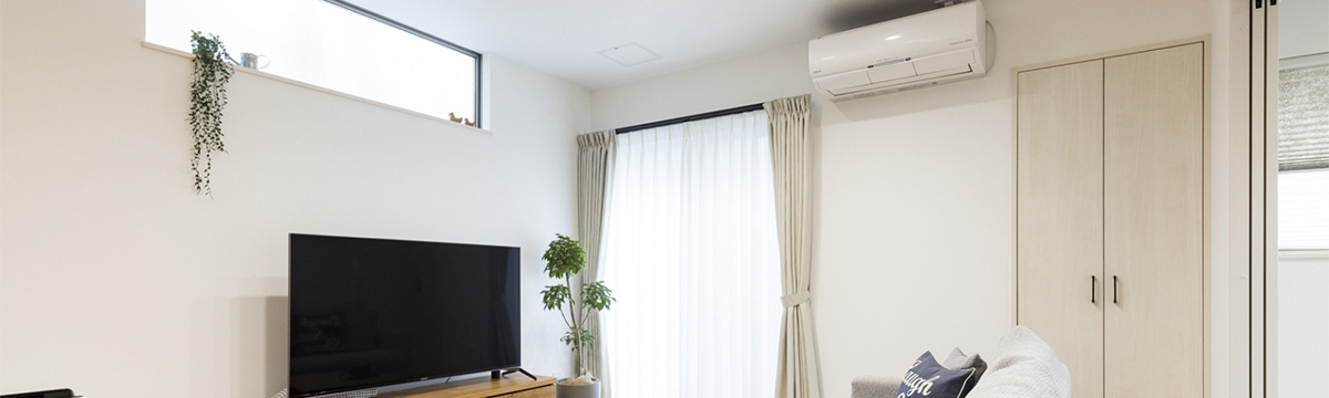 リビングの壁掛けエアコンとテレビがある明るい部屋の様子